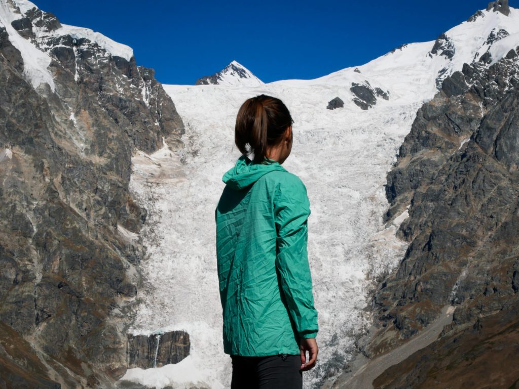 Erika and the mountain glacier between Adishi and Iprari on the Mestia to Ushguli trek in Svaneti, Georgia