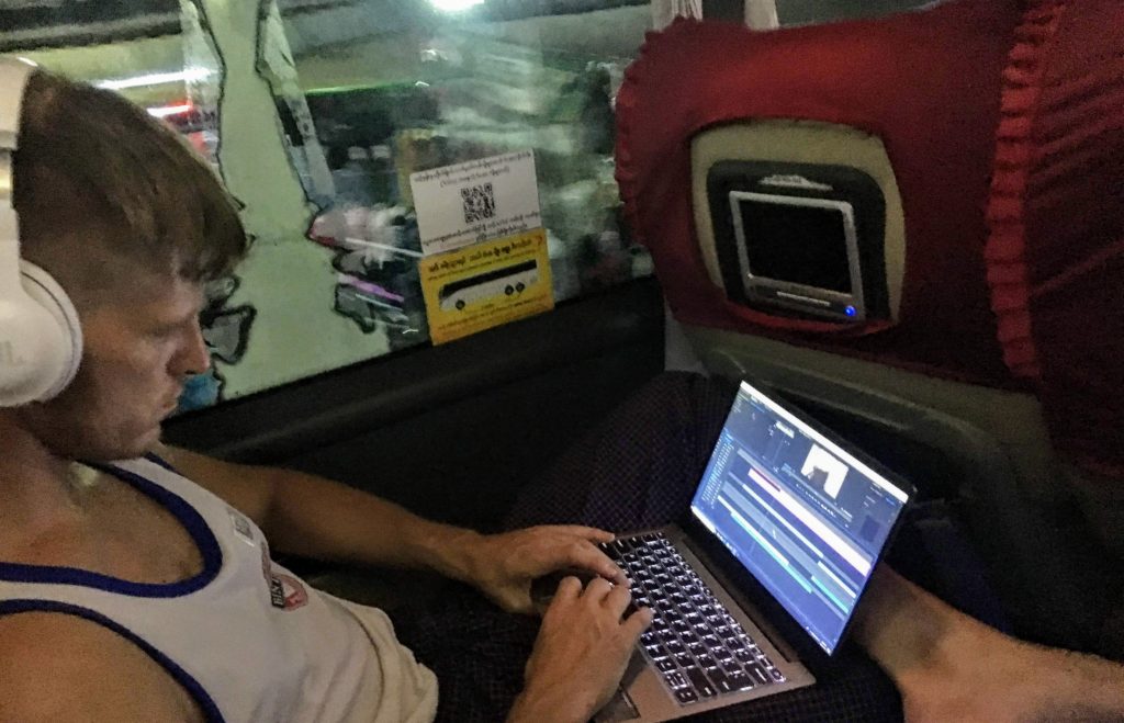 Marty of Intrepid Road working on YouTube videos from Yangon to Bagan overnight bus, Myanmar